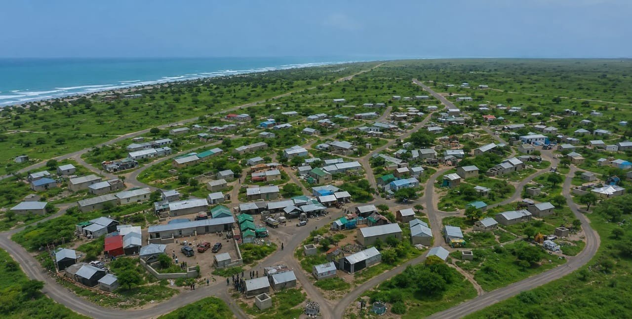 Dhinowda from the air: green ground and trees between the houses